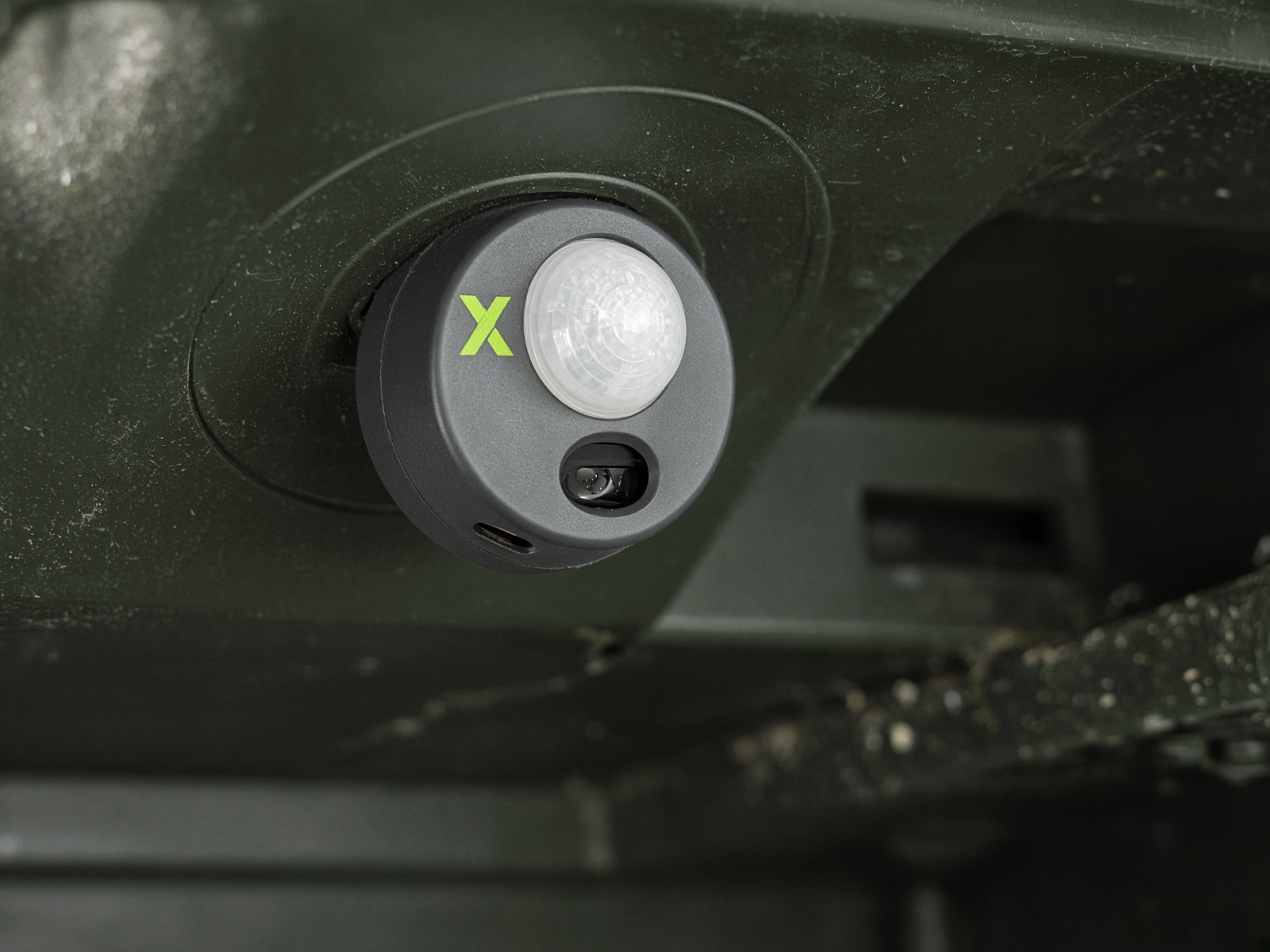 Rodent Trax puck mounted on the underside of a bait station lid